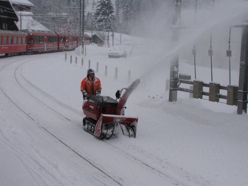 rhb sneeuwvrij maken.jpg - Links en rechts is personeel van de Rhätische Bahn bezig om de sneeuw te verwijderen bij de stations.